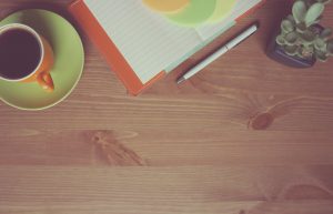 office desk with a coffee and a notebook